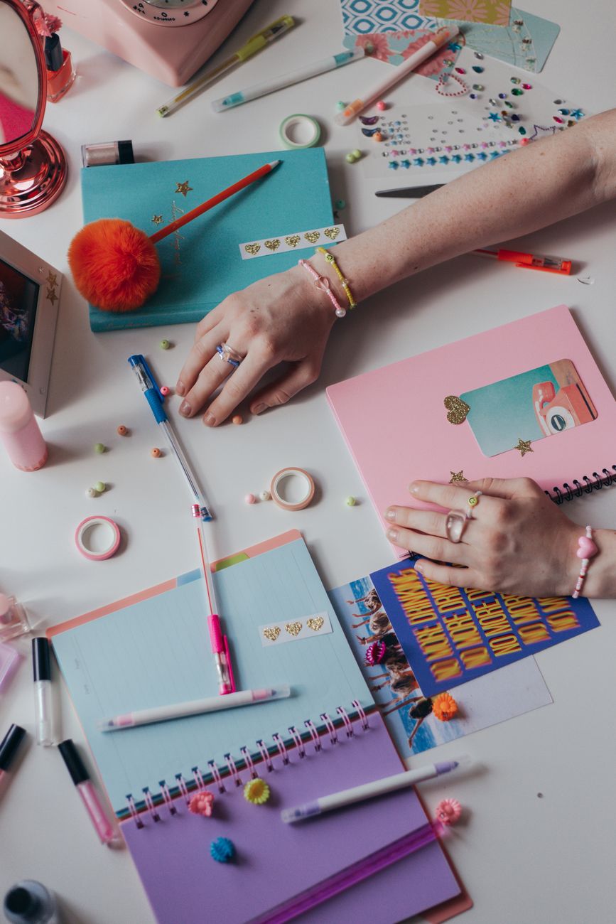 A collection of vibrant journals and stationery items on a desk, perfect for creative planning or journaling.
