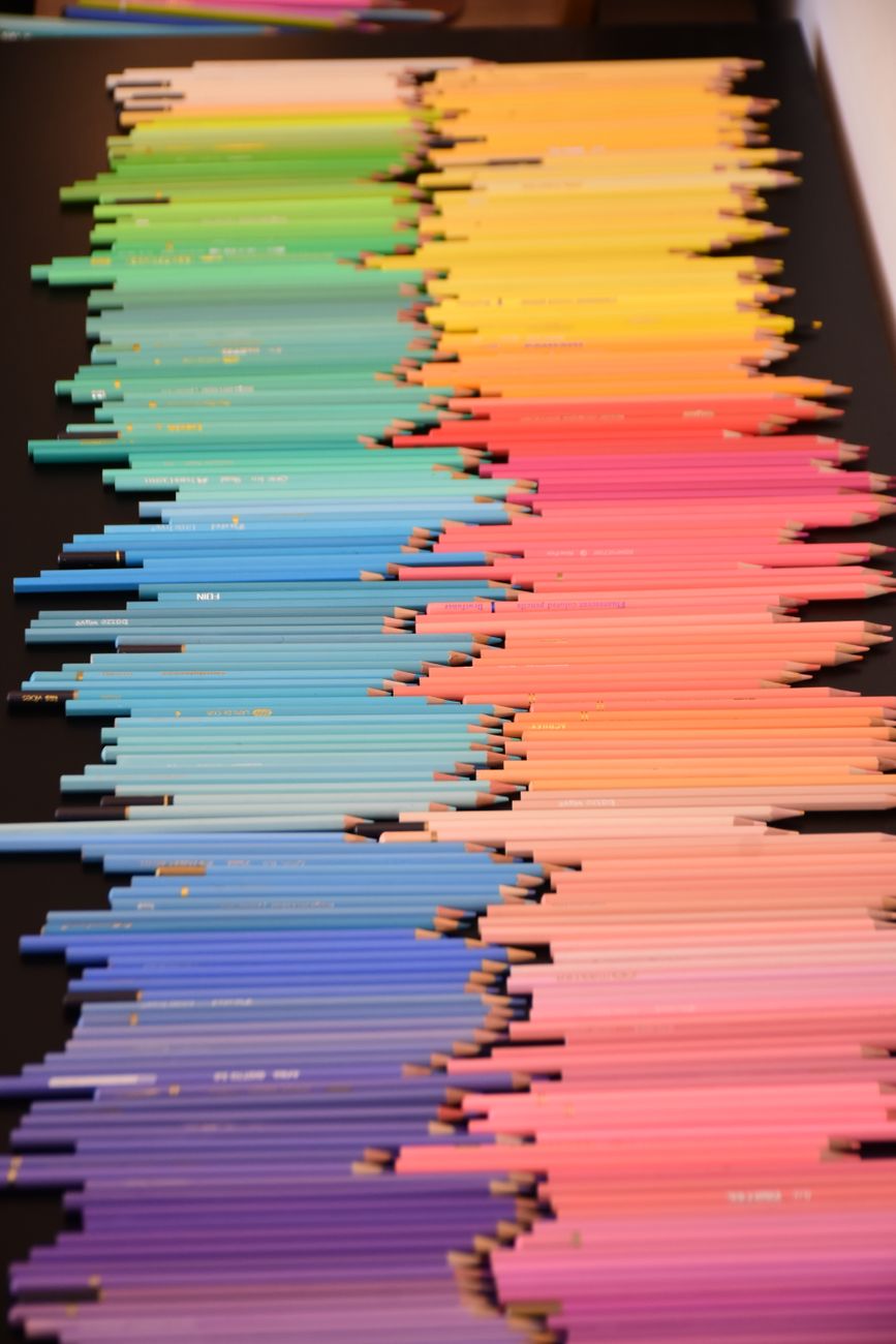 Vibrant rainbow-colored pencils neatly arranged for artistic inspiration. Ideal for creative projects.