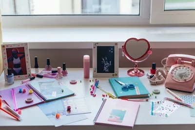 A vibrant desk setup with colorful stationery, decorations, and a vintage telephone.