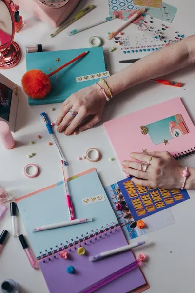 A collection of vibrant journals and stationery items on a desk, perfect for creative planning or journaling.