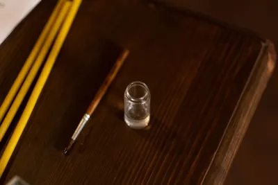 A detailed image of religious items including votive candles and a brush on a wooden table.