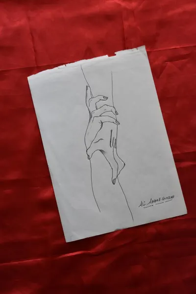 Minimalist line drawing of interlocking hands on paper against vibrant red fabric, conveying a sense of connection.