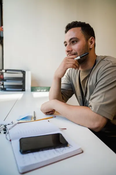 A man ponders ideas at his office desk, capturing a thoughtful moment.