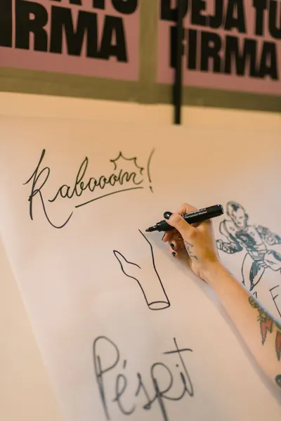 Close-up of a hand drawing comic art with a marker on paper.