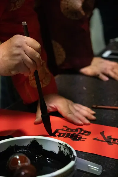 Close-up of traditional Chinese calligraphy writing with brush and ink, showcasing cultural artistry.