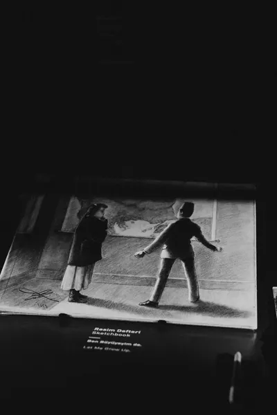A black and white photo of an art exhibit depicting two figures, taken in a museum in Türkiye.