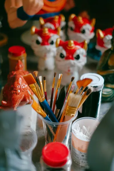 A vibrant assembly of paintbrushes and traditional lion statues creating an artistic atmosphere.