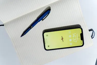 Open notebook with a pen and smartphone, perfect for productivity themes.