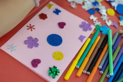 A vibrant handmade card decorated with glitter and stickers, perfect for creative projects.