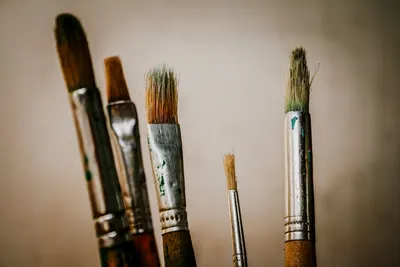 A detailed view of various paintbrushes used for artistic projects in a studio setting.