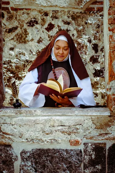 A serene nun in habit reading a book by a stone monastery window, exuding tranquility.