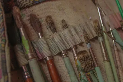 A collection of paintbrushes in a textured holder, perfect for art enthusiasts and creators.