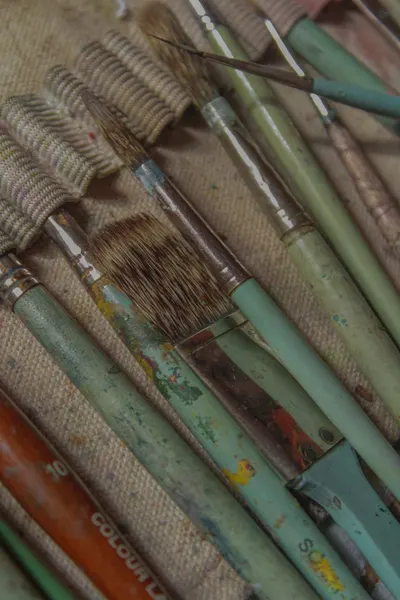 A detailed shot of well-used paintbrushes on canvas, showcasing creativity and artistic expression.