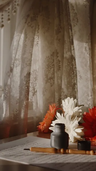 A serene still life composition featuring daisies, an ink pot, and lace curtains in soft lighting.