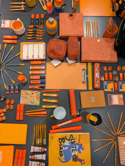 A vibrant collection of orange-themed office supplies arranged for design inspiration.