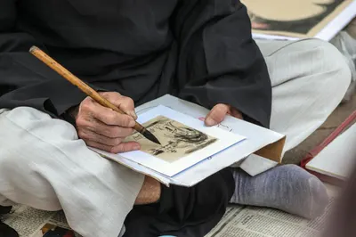 Close-up of traditional Asian calligraphy being created with a brush pen, showcasing cultural artistry.