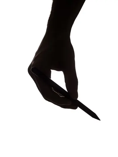 Artistic silhouette of a hand gripping a pencil against a white background, emphasizing creativity and design.
