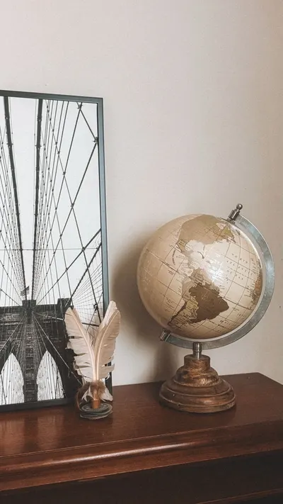 Timeless decor with a vintage globe and feather quill on a wooden surface.