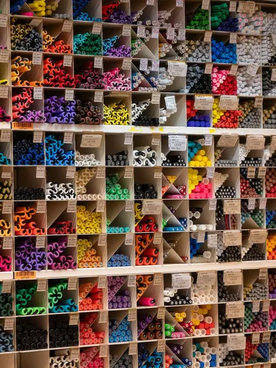 Vibrant array of art supplies neatly organized in shelves, offering a rainbow of colors and textures.