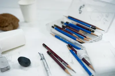 A collection of sketching tools and art supplies arranged on a desk, ideal for artists.