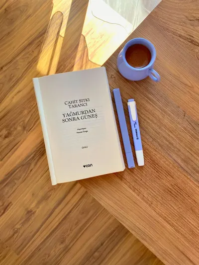 A relaxing scene with a book, pen, and coffee cup on a wooden table.