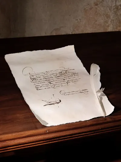 Old manuscript with quill on table, evoking a historical and vintage atmosphere.