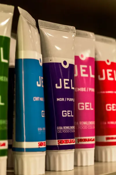 Close-up of colorful food gel tubes displayed on a store shelf under bright lighting.