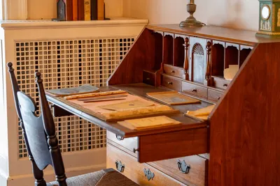 A charming wooden desk with vintage writing supplies in a cozy room.