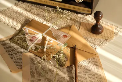 Beautifully arranged vintage stationery set with envelopes, old pages, and flowers, perfect for nostalgic themes.