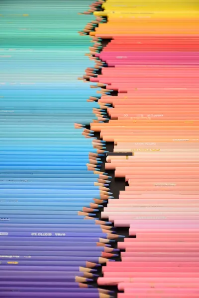 A vibrant arrangement of colored pencils creating a gradient effect, ideal for design projects.