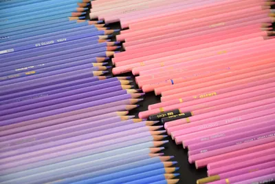 A vibrant collection of pink and purple colored pencils arranged in a pattern.