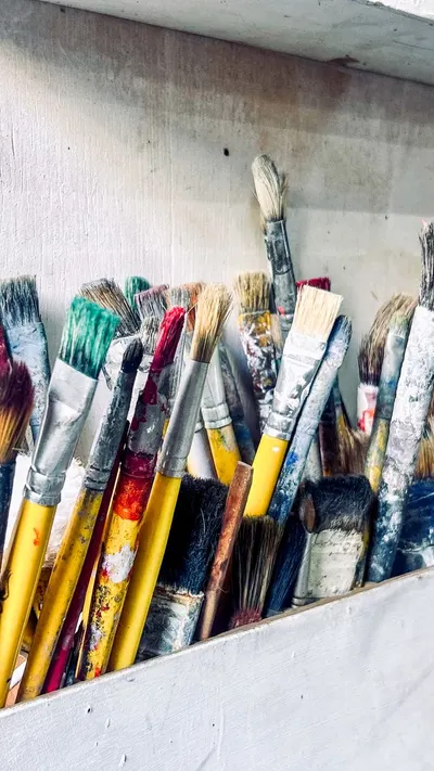 A collection of various paintbrushes used by an artist in their creative workspace.