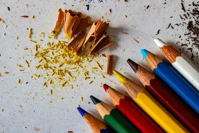 Close-up of colorful pencil shavings and crayons on paper, ideal for art and creativity themes.