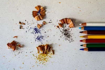 Vibrant colored pencils and shavings scattered on a paper surface, showcasing creativity.