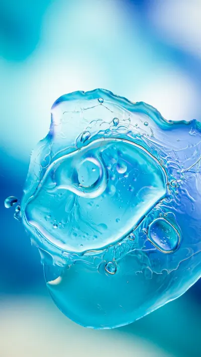 A stunning abstract close-up of a blue liquid bubble, highlighting texture and light refraction.