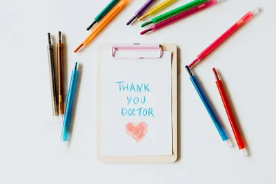 Creative thank you note for doctors on clipboard with pens symbolizing appreciation and gratitude.