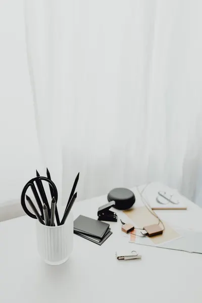 Minimalist office supplies on a white desk with a neutral background, showcasing a clean aesthetic.