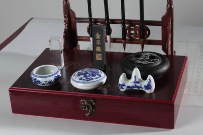 An elegant traditional Asian calligraphy set with brush pens and ink stone on a wooden box.