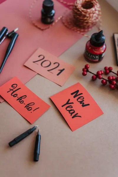Creative New Year 2021 stationery setup with calligraphy tools on paper.