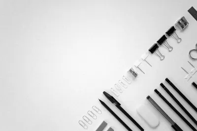 Flat lay of organized office supplies on a plain white surface, ideal for business or educational contexts.