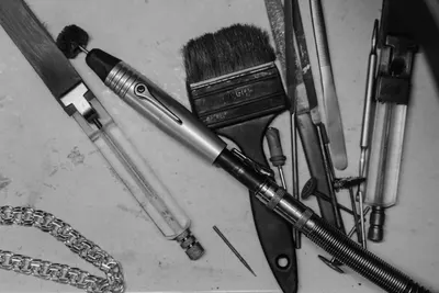 A monochrome image showcasing various tools used in jewelry making, emphasizing craftsmanship.