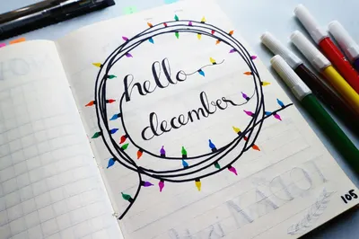 A December planner page featuring colorful calligraphy 'hello December' with artistic light decoration.