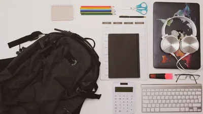 Top view of a clean desk with office supplies, tech gadgets, and stationery for efficient work.