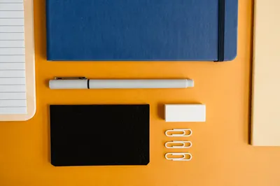 Flat lay of assorted stationery items on a vibrant yellow background for office or school use.
