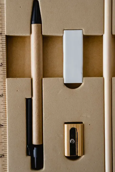 Vertical shot of a stationery set including a pen, eraser, and sharpener.