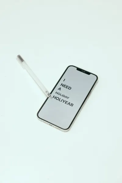 A smartphone displaying a humorous holiday message with a pen on a white background.