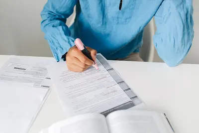 Person highlighting text on documents; ideal for study and work themes.