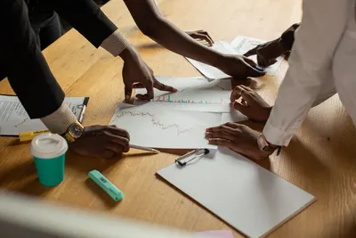 A diverse team collaborates on analyzing data charts during a meeting.